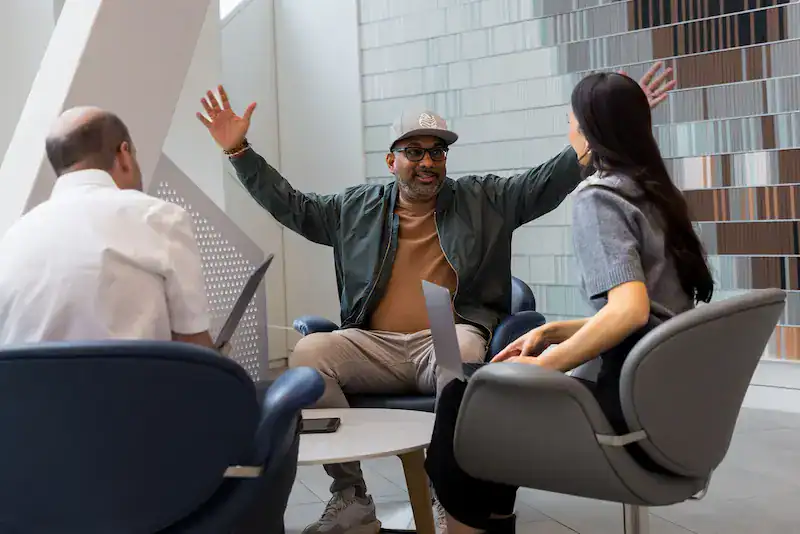 Stephen Ramkissoon talking through a client's story with two Marketing Guardians team members